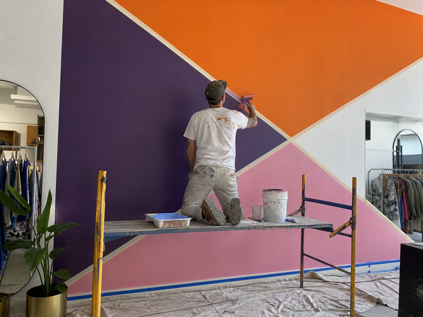 Artiste réalisant une fresque géométrique dans une boutique